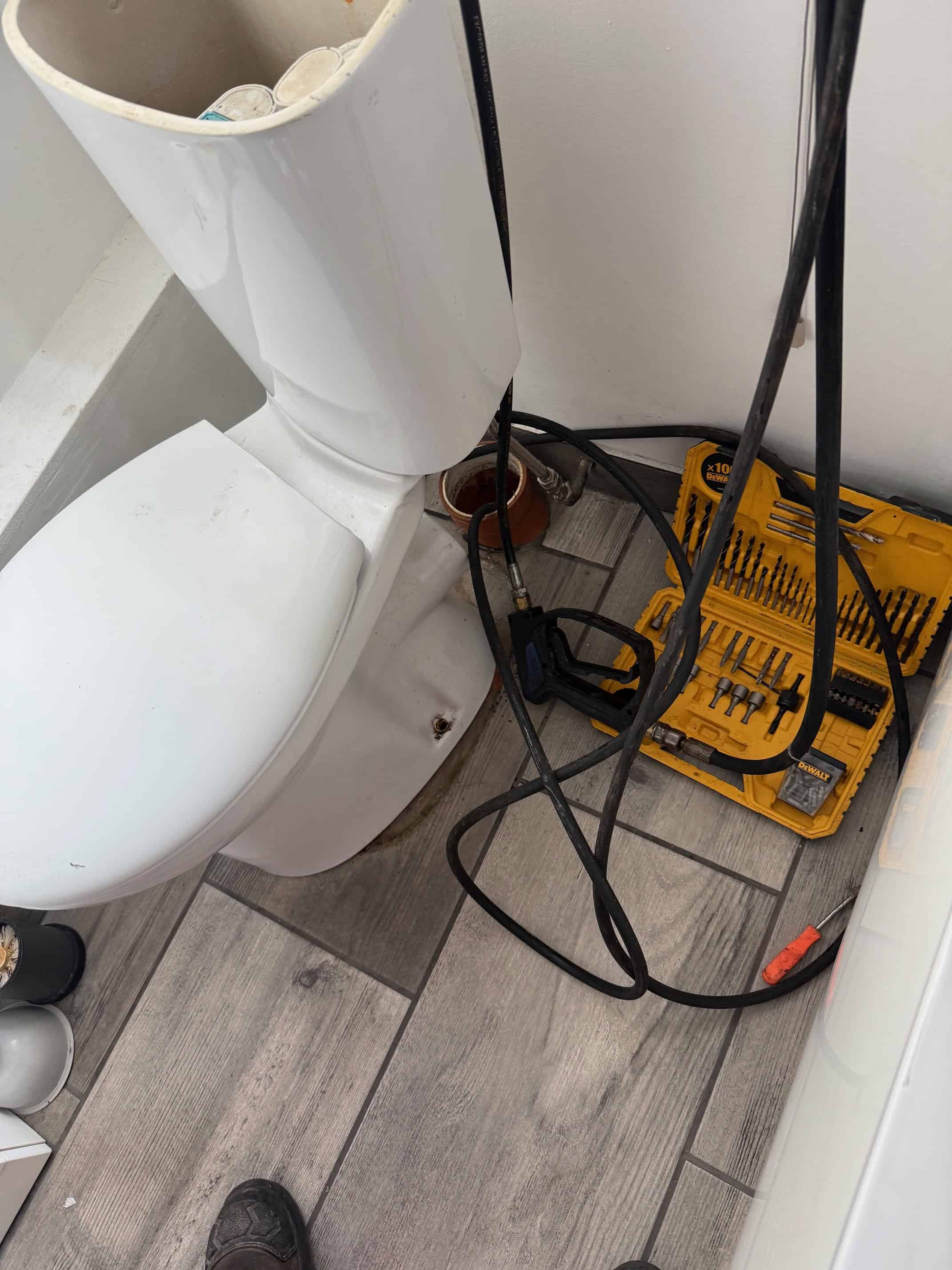 Professional blocked drain repair with plumbing tools and equipment.